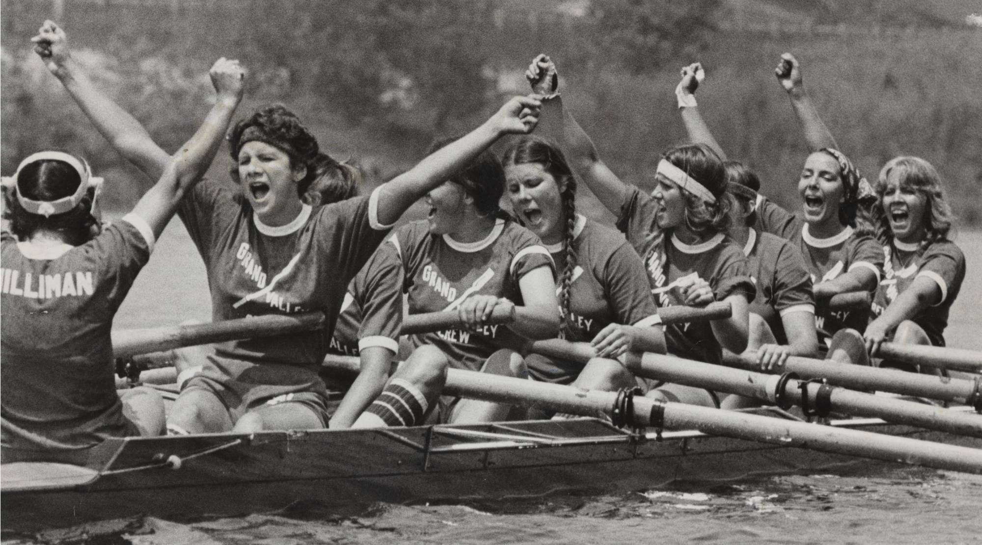 Women's rowing team members celebrate after a race